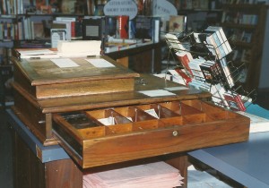 An old cash register at the Bookshelf in Madeira takes care of money without benefit of modern computerized parts, or even electricity.  The top has a hinged lid that lifts up to reveal a storage area.